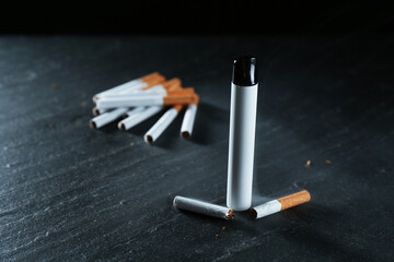 Electronic smoking device and cigarettes on black table