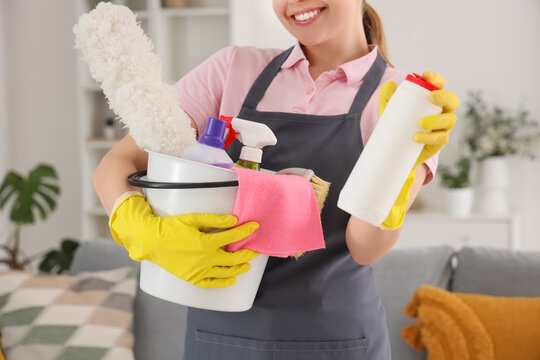 Young woman with baking soda and cleaning supplies in room, closeup