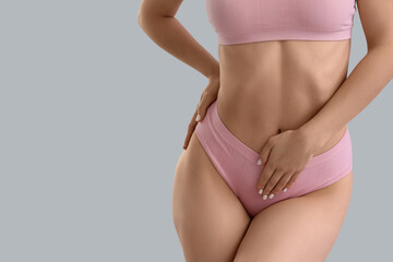 Young woman in underwear on grey background, closeup