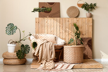 Interior of stylish living room with armchair, wicker basket and plants