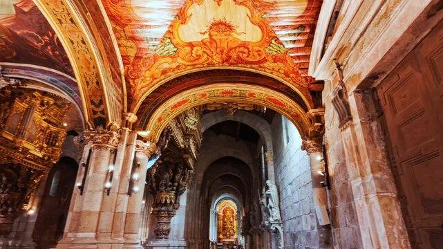 Braga Cathedral interior reveals gilded altarpieces carved choir stalls and polychrome ceiling vaults glowing beneath soft candlelight in Braga, Portugal