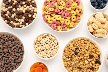 Bowls with different tasty cereals on white background