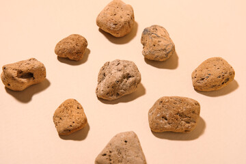 Many sea stones on beige background, closeup