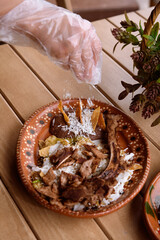 putting grated cheese on chilaquiles