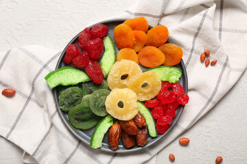 Plate with different candied fruits and peanuts on white background