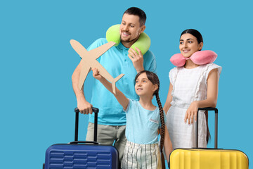 Family of tourists with paper airplane and suitcases on blue background
