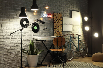 Interior of recording studio with synthesizer and glowing lamps at night