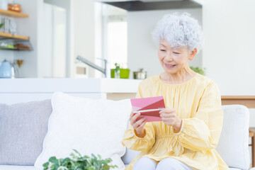 観葉植物に水をやるシニアの女性