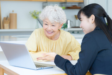 リビングでシニア女性と商談をするビジネスウーマン