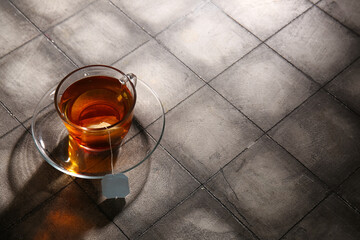 Cup of hot tea on grey tile background