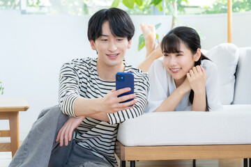 リビングでくつろぐ若いカップル