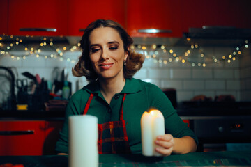 Woman Lighting Candles As Table Decorations for Dinner. Happy housewife making last minute preparation for Christmas gathering