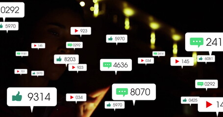 Holding smartphone woman wearing dark clothing viewing floating media icons in dim room, copy space