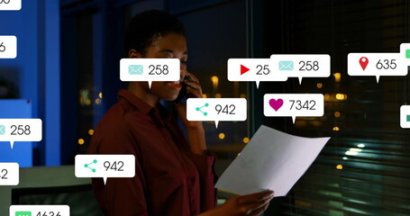 Wearing button-up shirt, analyzing smartphone and document with notifications in office at night