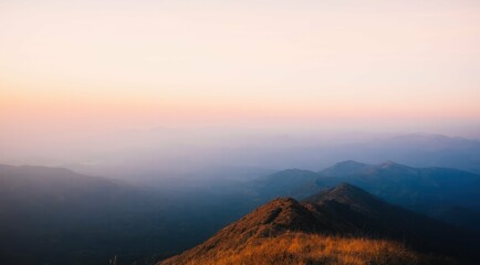 Obraz premium Mountains at sunset with haze and warm light