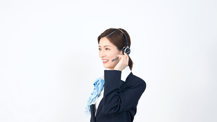 Female staff wearing a headset in front of white background.