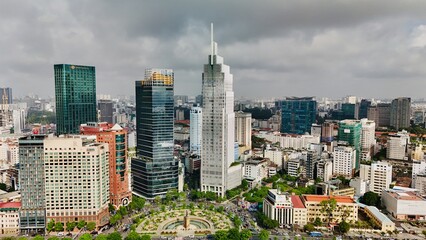 Ho Chi Minh City, Vietnam: Aerial Drone Image of Downtown Skyline, Saigon River, Ba Son Bridge, and Busy Traffic, Roundabout, Parklands on a Cloudy Day in Southeast Asia Vibrant Urban Centre