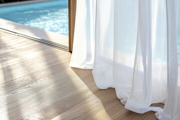 Sheer white curtains billow slightly open, revealing a pool beyond a sliding glass door. Sunlight streams across light-colored hardwood floors
