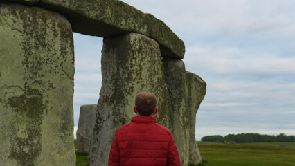 Person standing among Stonehenge in England, UK