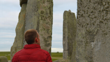 Person standing among Stonehenge in England, UK
