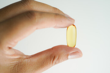Male hand holding Oil filled capsules, softgel of food supplements, fish oil, omega 3, vitamin E