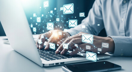 Businessman working on a laptop in a modern office, sending emails as part of direct digital marketing and network communication.