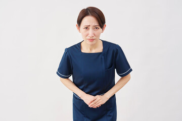 女性　美容看護師　お辞儀　謝罪　カメラ目線　白背景