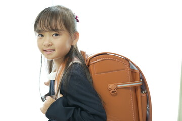 新一年生の女の子がランドセルを背負って登校する様子