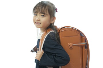 新一年生の女の子がランドセルを背負って登校する様子