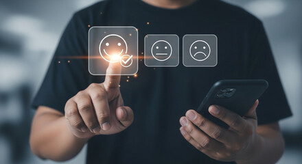 Customer feedback concept. A businessman selects a smile emoticon on a virtual screen using his smartphone.