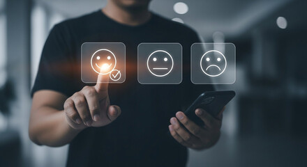 Customer service evaluation concept. A businessman presses a smiling face emoticon displayed on a virtual screen via smartphone.
