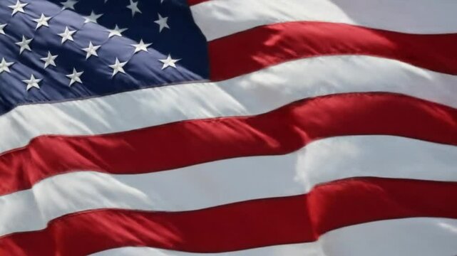 Close up view of the american flag waving with red and white stripes and blue field with stars