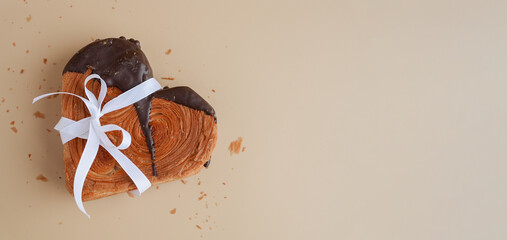 Tied bow ribbon present gift greeting holiday card Heartshaped pastry croissant treat topped with...