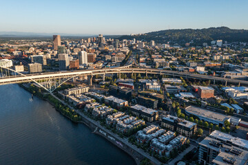 Aerial drone picture of Portland’s Fremont Bridge at sunset, the Willamette River, Downtown Portland, industrial area, and Mt. Hood in the background, with clear blue summer sky