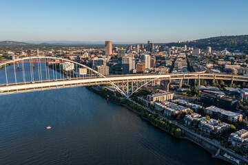 Obraz premium Aerial drone picture of Portland’s Fremont Bridge at sunset, the Willamette River, Downtown Portland, industrial area, and Mt. Hood in the background, with clear blue summer sky