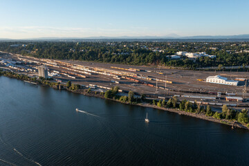 Aerial drone picture of Portland&rsquo;s industrial district near Willamette river, at sunset, showing train tracks, docks, parking lots, trains, railways, apartment complexes. Oregon, USA.