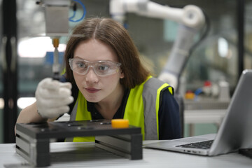 Caucasian engineer woman working on AI technology in robotics electronics engineering laboratory. University students' research project is programming robot machine with intelligent mechanical control