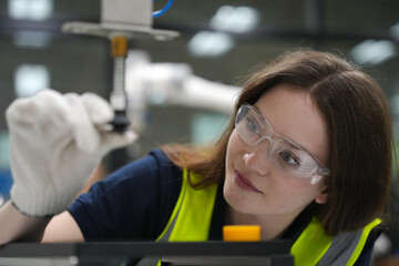 Caucasian engineer woman working on AI technology in robotics electronics engineering laboratory. University students' research project is programming robot machine with intelligent mechanical control