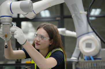 Caucasian engineer woman working on AI technology in robotics electronics engineering laboratory. University students' research project is programming robot machine with intelligent mechanical control