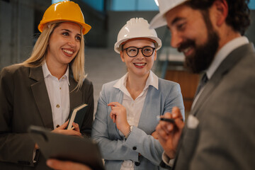 Engineers and architects discussing a building project wearing hardhats