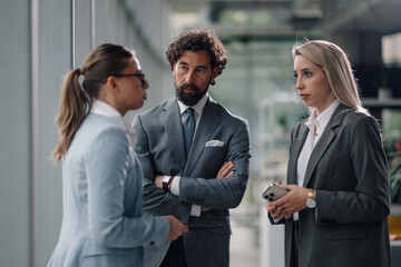 Business people talking and discussing in modern office corridor