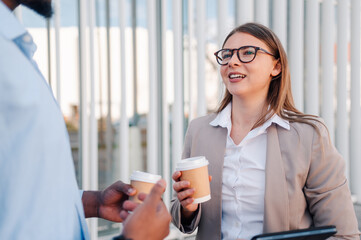 Business people talking and drinking coffee outdoors during break