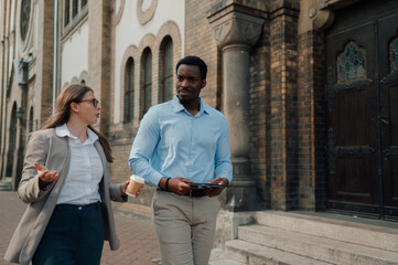 Business colleagues discussing work while walking near church