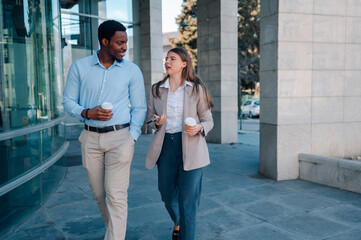 Business colleagues walking and talking outside office building