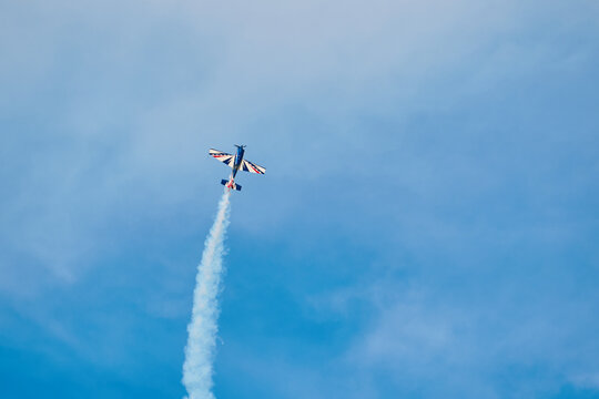 Aerobatic Airplane Performing Smoke Maneuver in Blue Sky