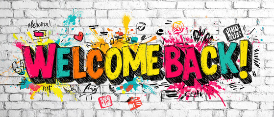 Colorful Welcome Back graffiti on brick wall