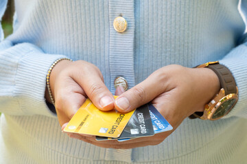 Woman holding several credit cards and he is choosing a credit card to pay and spend Payment for...