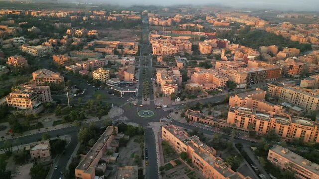 Aerial panoramic view of Marrakech city at sunrise with soft morning light illuminating terracotta buildings and streets in Morocco