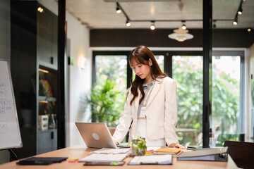 Happy young business woman officer in office using laptop at work, smiling professional female...