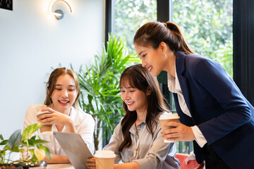 Colleagues taking a coffee break and enjoying a moment together at the office. Business Woman using...